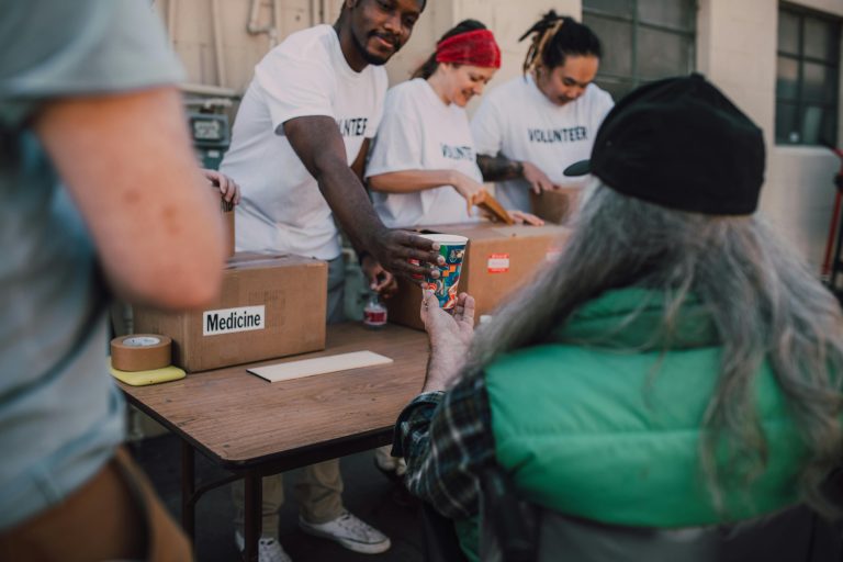 Volontaires distribuant des dons et apportant un soutien aux personnes dans le besoin lors d'un événement communautaire.