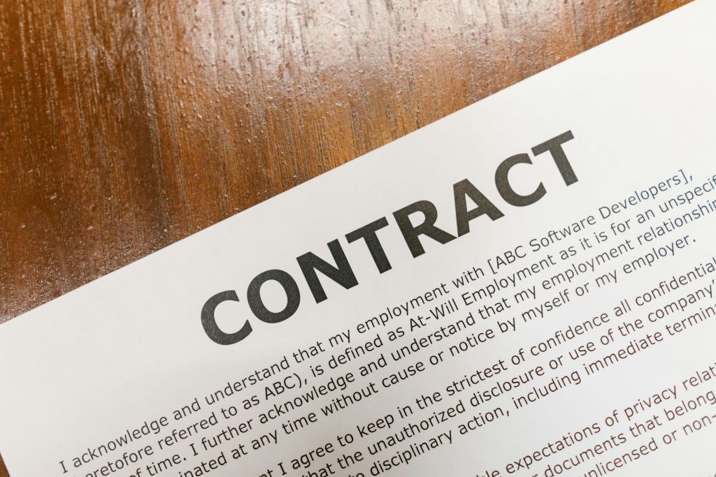 Un gros plan détaillé d'un document de contrat imprimé sur une surface en bois.