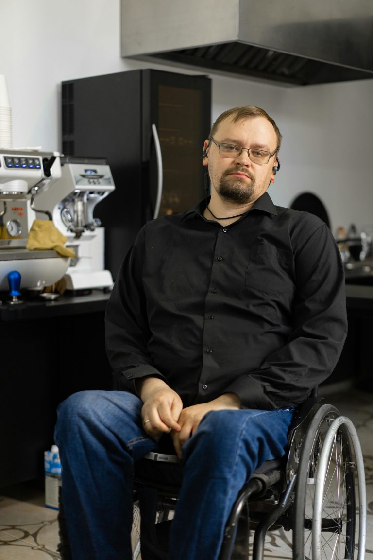 Barista en fauteuil roulant travaillant dans un café, illustrant l'inclusivité