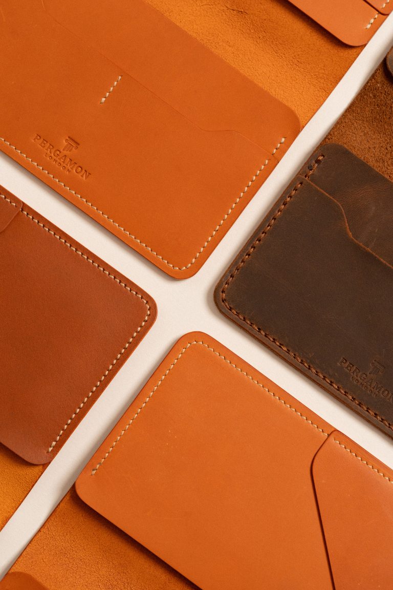 A top view of a collection of luxury leather wallets and cardholders showcasing craftsmanship and elegance. Vue de dessus d'une collection de portefeuilles et porte-cartes en cuir de luxe mettant en valeur le savoir-faire et l'élégance.