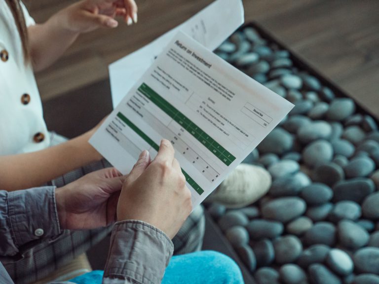 Two people discussing a financial document showing return on investment data. Deux personnes discutant d'un document financier montrant les données de retour sur investissement.