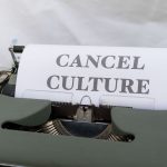 Close-up of a vintage typewriter with paper reading 'Cancel Culture', signifying social media trends. Gros plan d'une machine à écrire vintage avec du papier affichant « Cancel Culture », signifiant les tendances des médias sociaux.