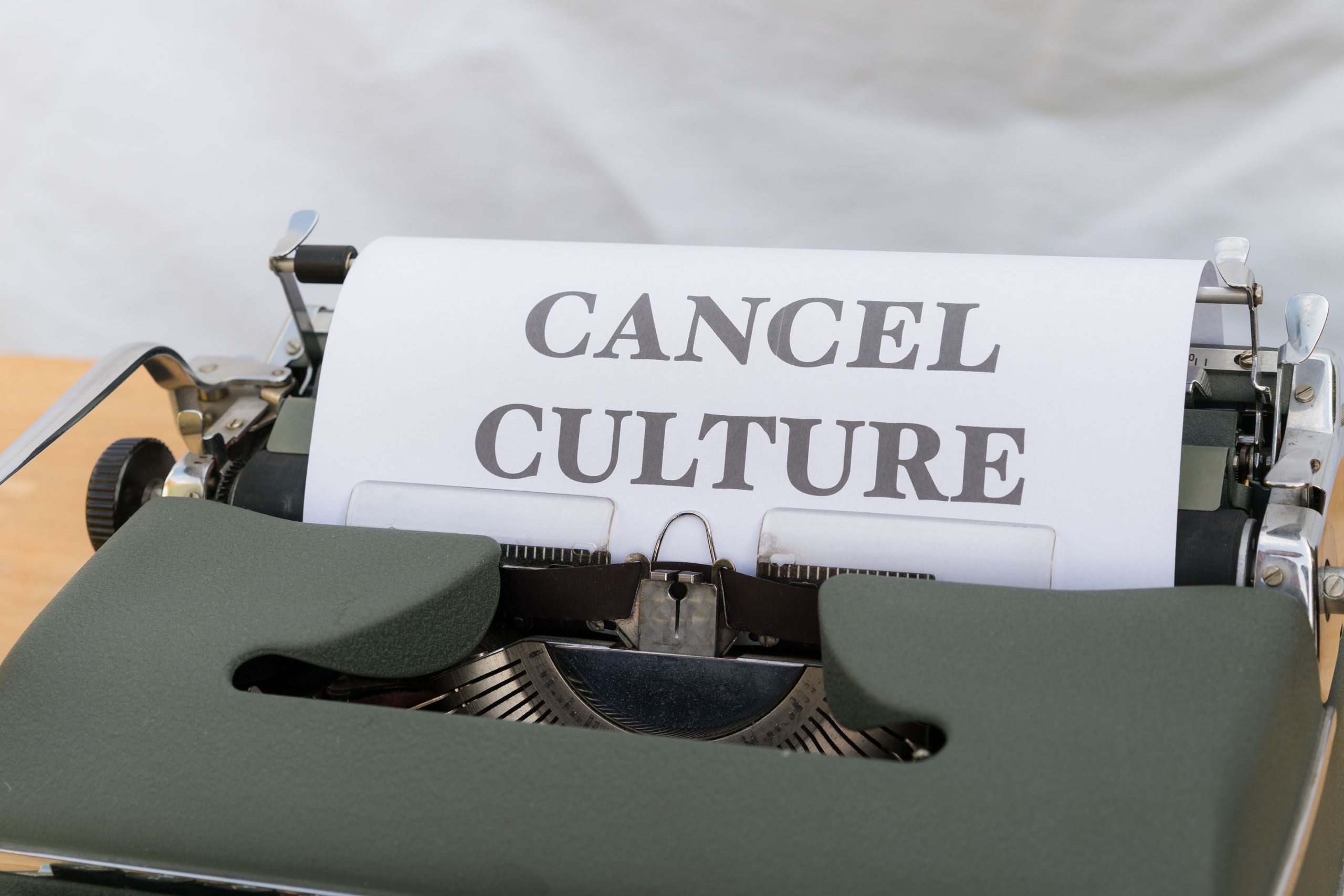 Close-up of a vintage typewriter with paper reading 'Cancel Culture', signifying social media trends. Gros plan d'une machine à écrire vintage avec du papier affichant « Cancel Culture », signifiant les tendances des médias sociaux.