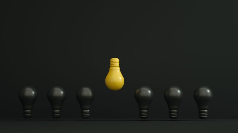 A single yellow light bulb highlighted among dark ones symbolizing creativity and innovation. Une seule ampoule jaune mise en évidence parmi des ampoules sombres symbolisant la créativité et l'innovation.