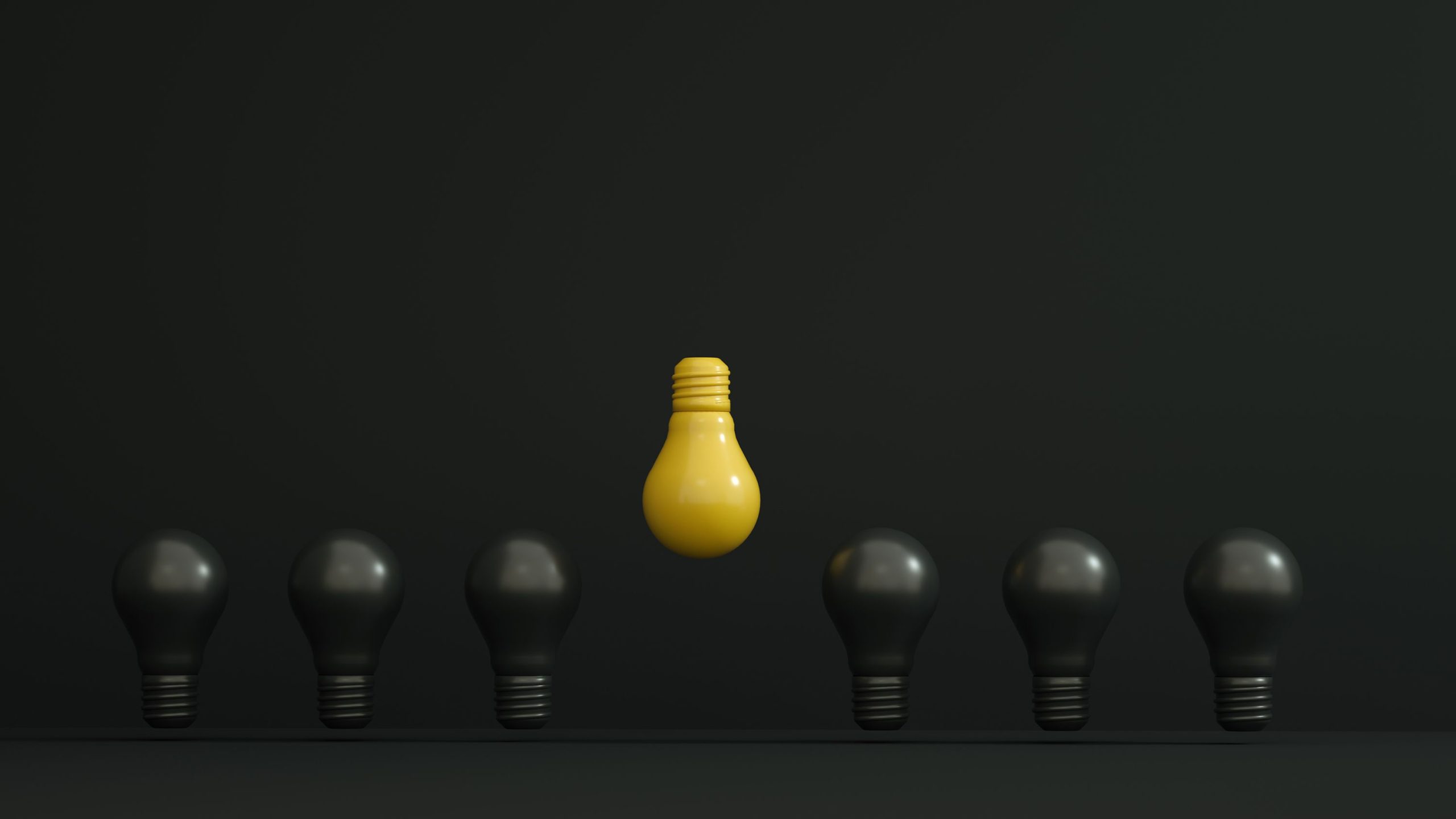 A single yellow light bulb highlighted among dark ones symbolizing creativity and innovation. Une seule ampoule jaune mise en évidence parmi des ampoules sombres symbolisant la créativité et l'innovation.
