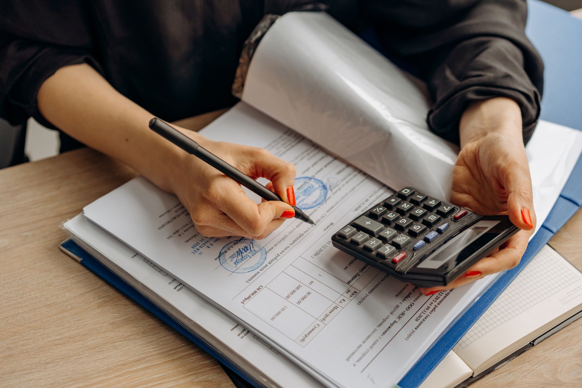 Calculatrice et documents comptables tenus en main