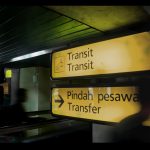 Illuminated transit signs at an airport in Banten, Indonesia, guiding passengers. Panneaux de transit illuminés à un aéroport à Banten, en Indonésie, guidant les passagers.