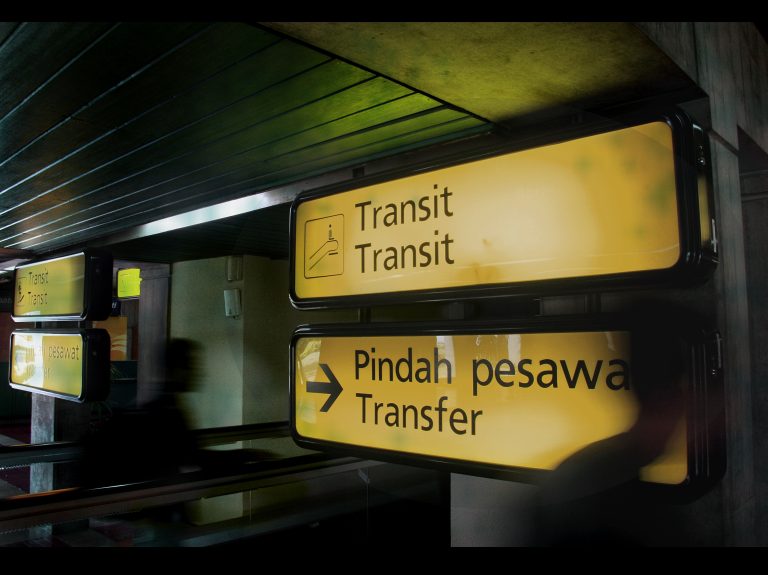 Illuminated transit signs at an airport in Banten, Indonesia, guiding passengers. Panneaux de transit illuminés à un aéroport à Banten, en Indonésie, guidant les passagers.