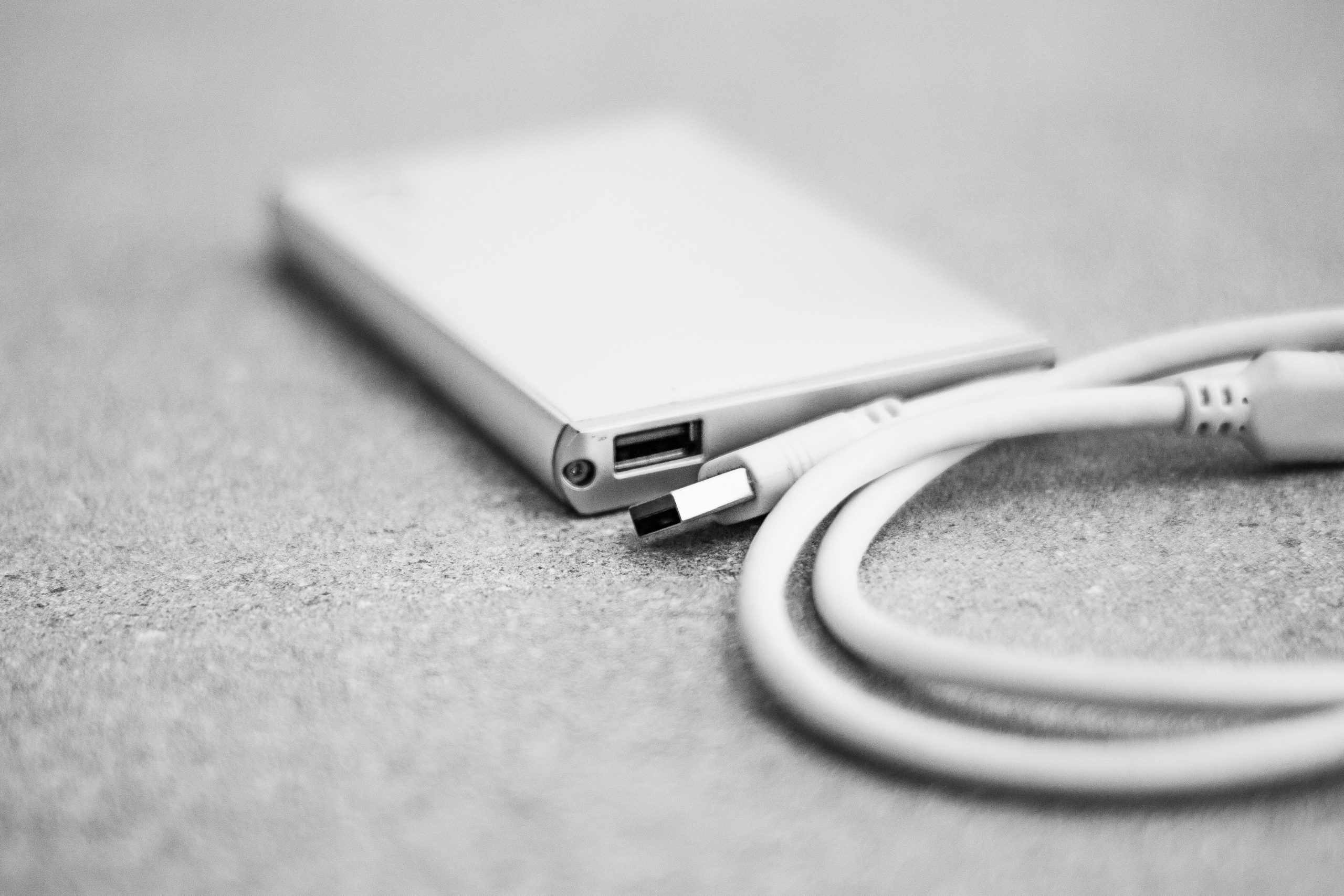 Disque dur externe noir et câble USB en gros plan