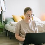 Freelance concentré devant son ordinateur portable dans une chambre lumineuse