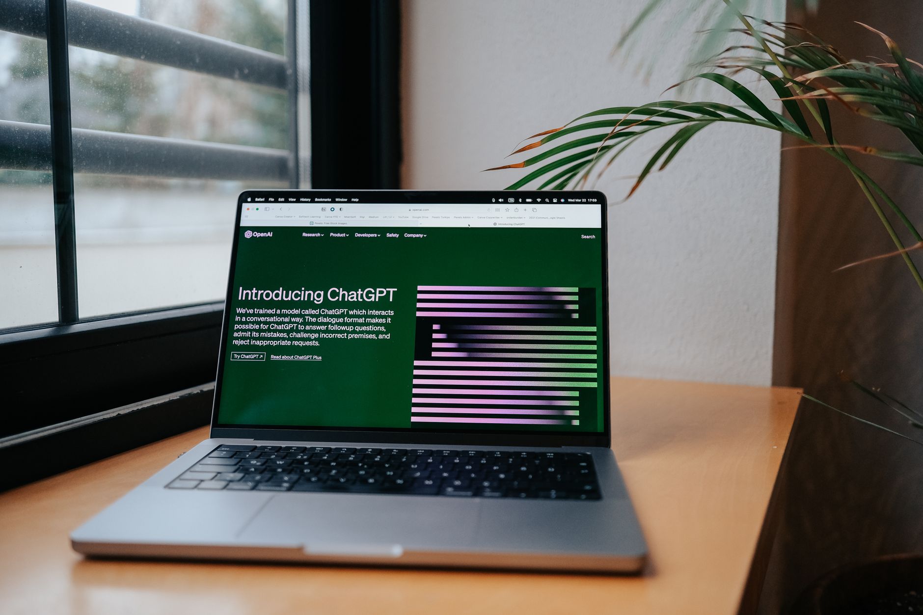 Portable ouvert sur un bureau devant une fenêtre