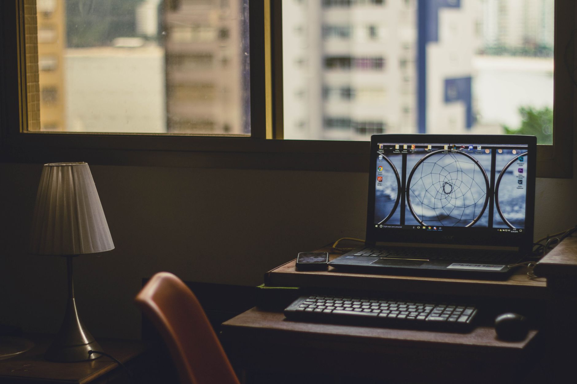 Ordinateur portable posé sur un bureau près d’une lampe